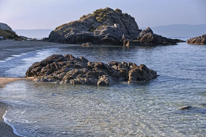 Framed Print : Clear waves lapping rocky coast with calm sea and bright beach Framed Print : Clear waves lapping rocky coast with calm sea and bright beach