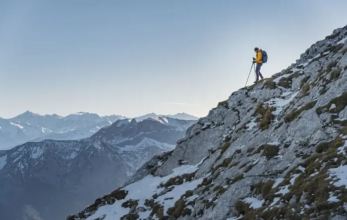Framed Print : Climber on a ledge, snow-covered mountains