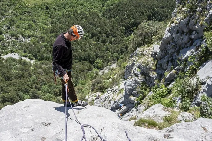Framed Print : A climber in safety equipment descends a rocky mountain face
