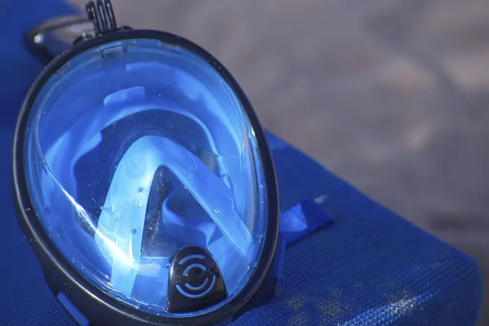Framed Print : Close-up of a blue diving mask on a blue surface by the beach