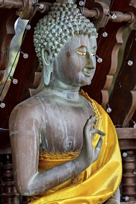 Framed Print : Close-up of a Buddha statue in bronze with a bright yellow cloth