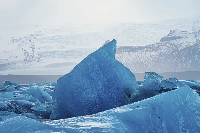 Framed Print : Close-up of a large blue iceberg against a mountainous background Framed Print : Close-up of a large blue iceberg against a mountainous background