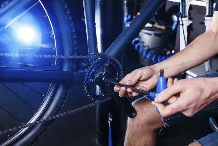 Framed Print : A close-up of a male bicycle mechanic's hand in the workshop uses a screwdriver tool to adjust Framed Print : A close-up of a male bicycle mechanic's hand in the workshop uses a screwdriver tool to adjust