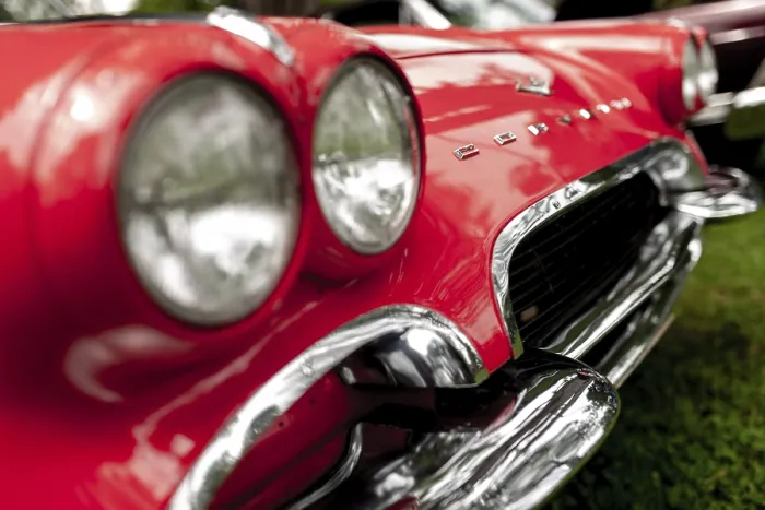 Framed Print : Close-up of a red vintage car's chrome headlights and grille