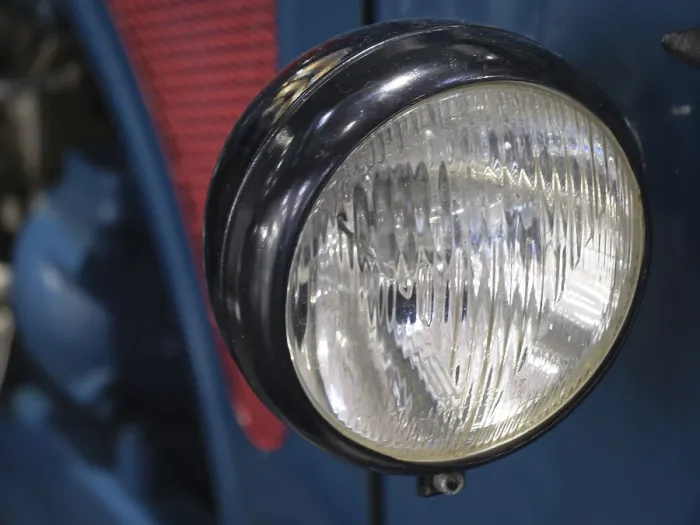 Framed Print : Close-up of a round headlight of a blue vintage car