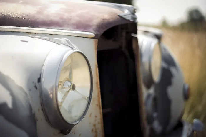 Framed Print : Close-up of a rusty vintage Jaguar car headlight and front body
