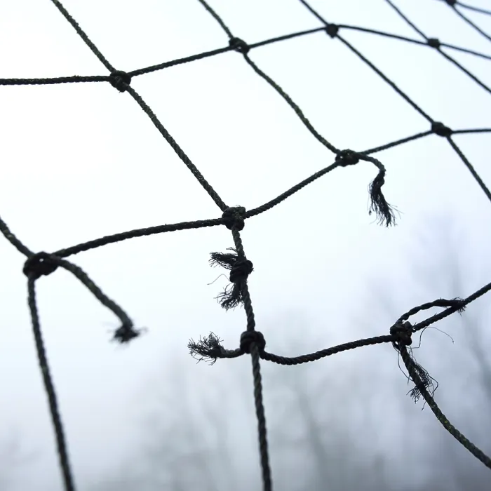 Framed Print : A close-up view of worn netting with frayed edges