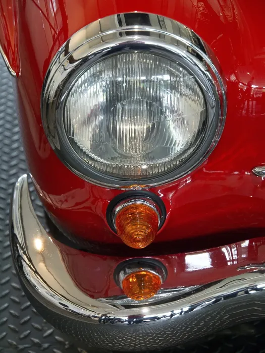 Framed Print : Close-up of a vintage car headlight with red details