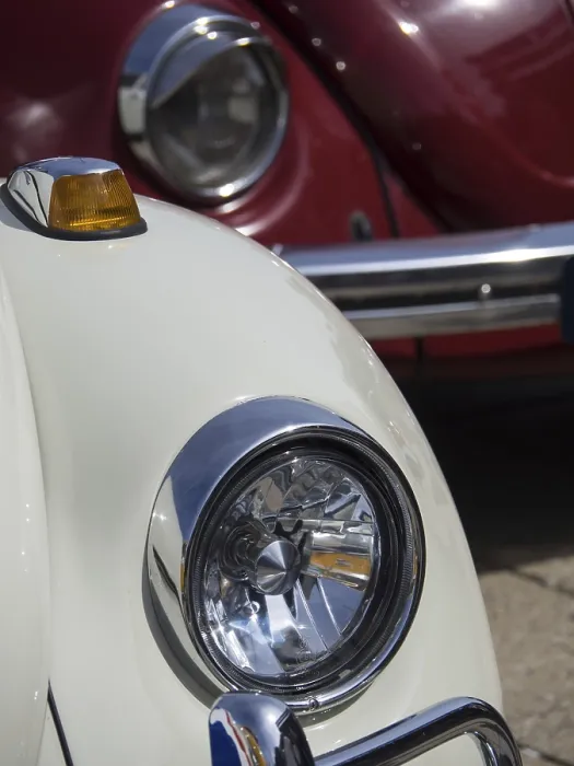 Framed Print : Close-up of a white vintage car with red car in the background Framed Print : Close-up of a white vintage car with red car in the background