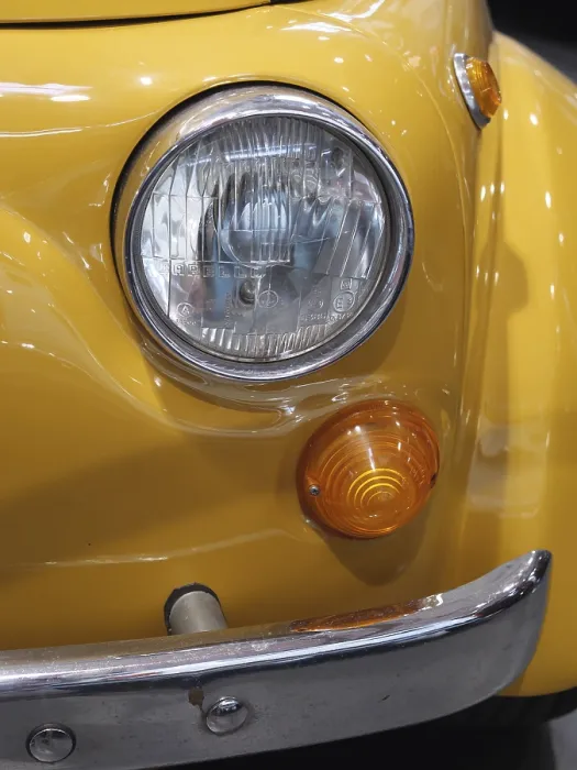 Framed Print : Close-up of a yellow vintage car front end with round headlight and indicators
