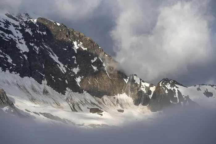Framed Print : Cloudy, atmospheric mountain landscape with snow-covered mountain peaks