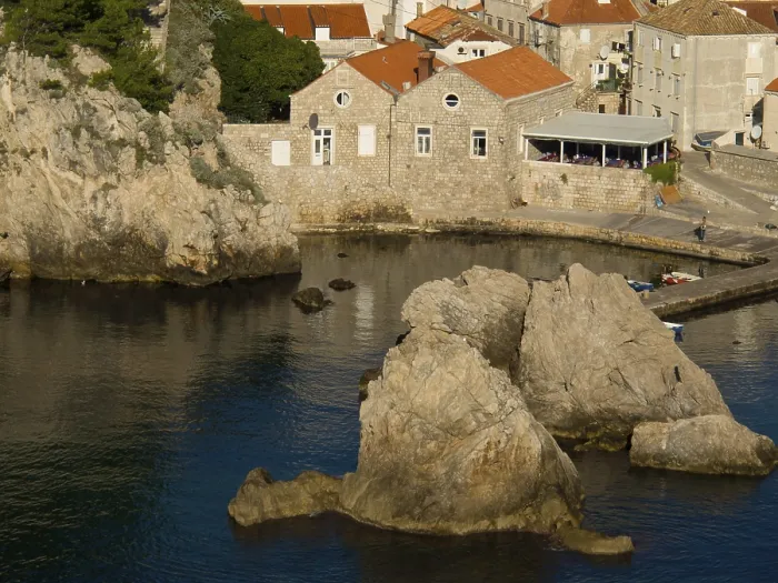 Framed Print : Coastal town with rocky shores and calm waters