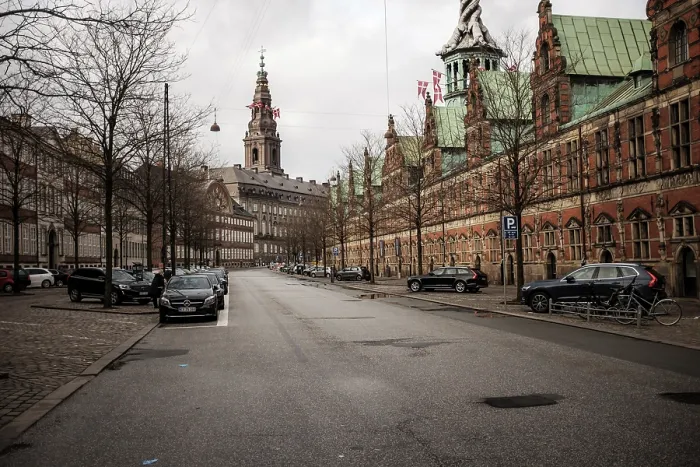 Framed Print : A cobblestone street with historical buildings and a cloudy sky in Copenhagen