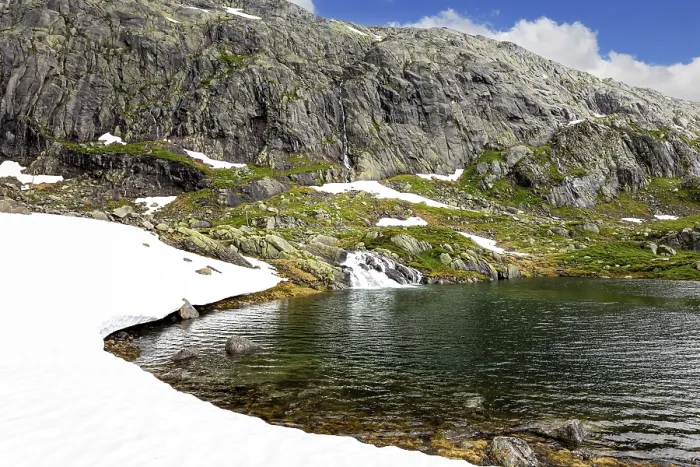 Framed Print : Cold summer in Norway. Large snowfields is reflected in the water of the lake