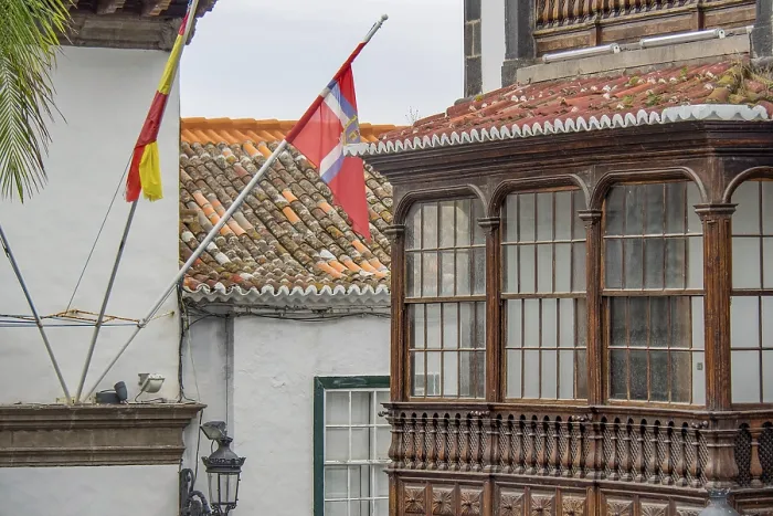 Framed Print : Detail of a colonial building with wooden balcony and waving flags