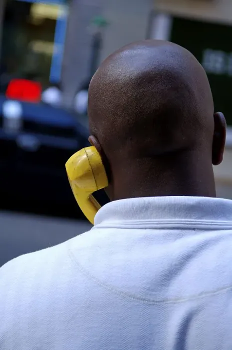 Framed Print : Coloured New Yorker talking on the phone with a yellow handset