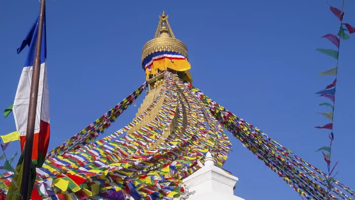 Framed Print : Colourful prayer flags surround the golden tip of a stupa
