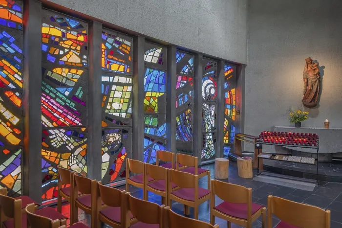 Framed Print : Colourful stained glass windows and a statue of the Virgin Mary with sacrificial candles