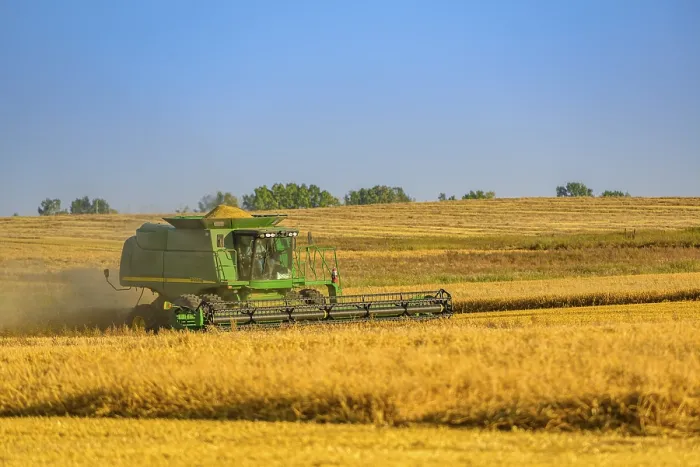 Framed Print : A combine machine harvesting a ripe crop of grain on the prairies