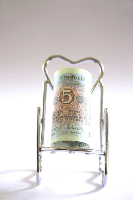 Framed Print : Concept, Indian currency five rupees on relax stainless steel chair Framed Print : Concept, Indian currency five rupees on relax stainless steel chair
