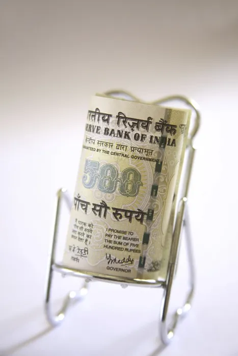 Framed Print : Concept, Indian currency five hundred rupees on relax stainless steel chair Framed Print : Concept, Indian currency five hundred rupees on relax stainless steel chair