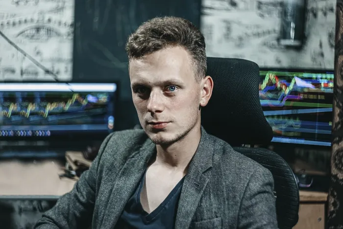 Framed Print : Confident man sitting in front of trading monitors in an office setting