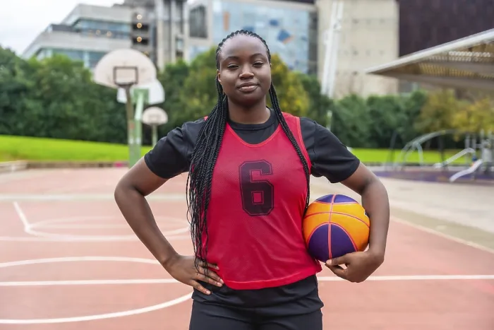 Framed Print : Confident young black woman athlete with braids wearing a red jersey