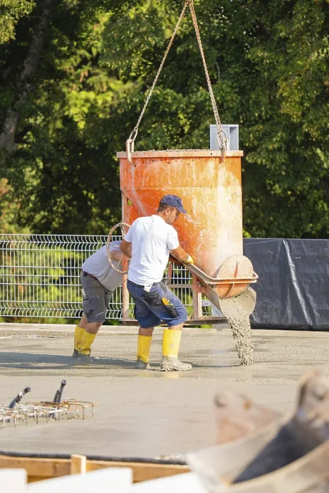 Framed Print : Two construction workers pouring concrete from a concrete mixer on a building site Framed Print : Two construction workers pouring concrete from a concrete mixer on a building site