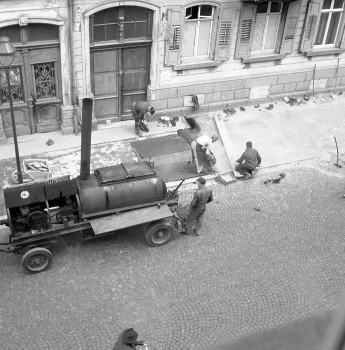 Framed Print : Construction workers repair and tar the pavement