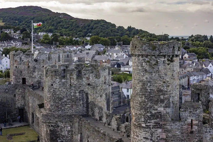 Framed Print : Conwy Castle, medieval castle with towers and surrounding town in a green landscape under a cloudy sky