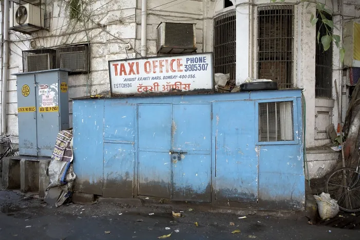 Framed Print : A corner of a building enclosed with a narrow structure serves as an office for taxi operators