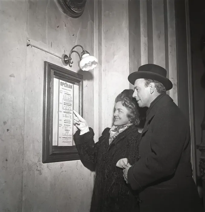 Framed Print : Couple in 1948. They stand at an information board Framed Print : Couple in 1948. They stand at an information board