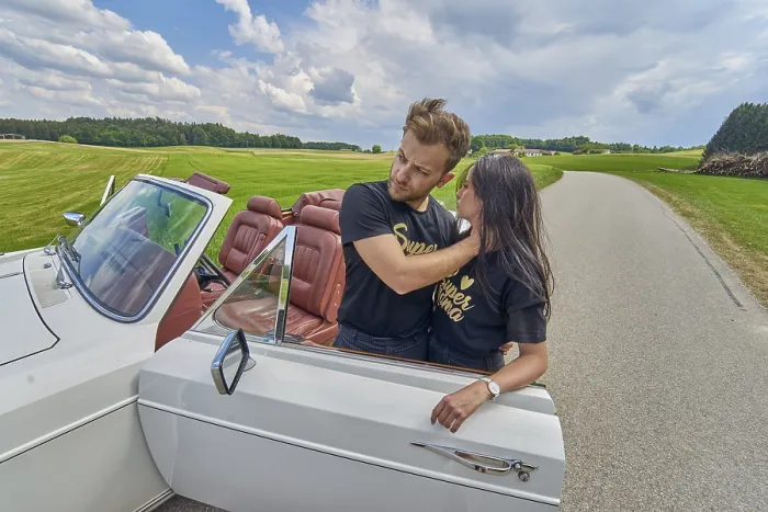 Framed Print : Couple embracing by a convertible car on a tranquil country road Framed Print : Couple embracing by a convertible car on a tranquil country road