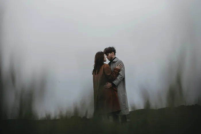 Framed Print : Couple embracing in a field under a cloudy sky Framed Print : Couple embracing in a field under a cloudy sky