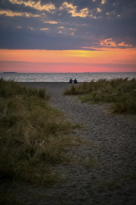 Framed Print : Couple sitting on the beach, Beach landscape with dune grass