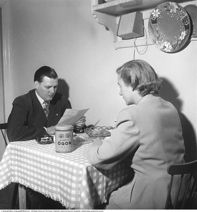 Framed Print : Couple at a Table in the 1950s A couple sits opposite each other at a small dining table