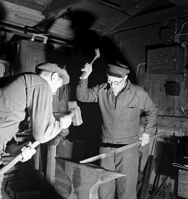 Framed Print : Craftsmen of the 1940s. Two blacksmiths in a forge, hammering a piece of metal against the anvil. Sweden 1947 Kristoffersson ref AB6-3