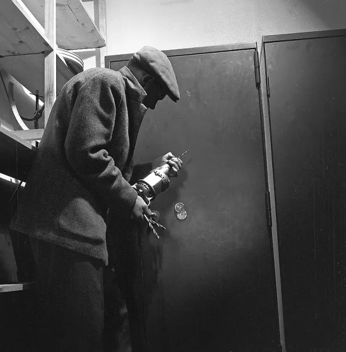 Framed Print : Crime in the 1960s. An arranged picture featuring a man preparing to break into a safe