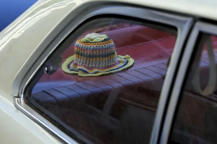 Framed Print : Crocheted toilet paper hat on the stacking of a vintage car