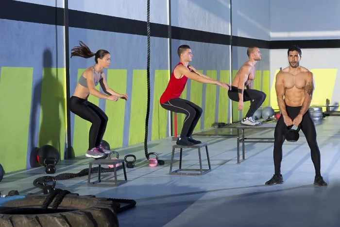 Framed Print : Crossfit box jump people group and kettlebell man at gym