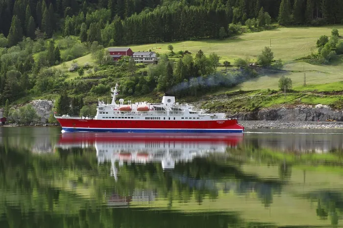 Framed Print : A cruise ship is reflected on a calm fjord in front of a green landscape