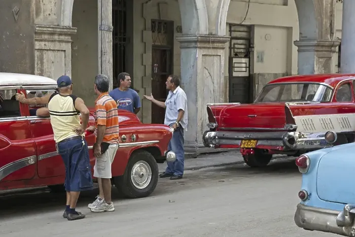 Framed Print : Cuban men discussing on street and red old 1950s vintage American cars Framed Print : Cuban men discussing on street and red old 1950s vintage American cars