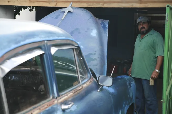Framed Print : Cuban standing next to his car as it is serviced Framed Print : Cuban standing next to his car as it is serviced