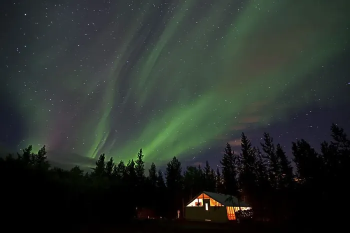 Framed Print : Curtains of northern polar lights and iluminated cabin