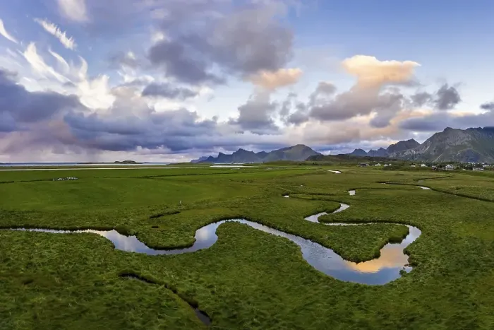 Framed Print : Curving river with mountains near Fredvang