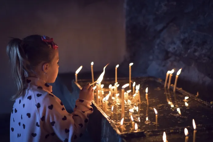 Framed Print : Cute little caucasian girl lightening the memorial candles in the monastery