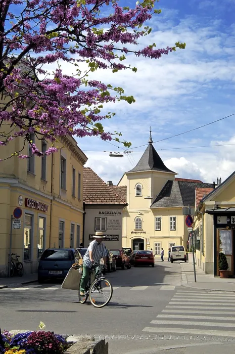 Framed Print : A cyclist and in the background the former townsmen hospital Baden Lower Austria
