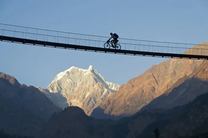 Framed Print : Cyclist crossing a suspension Bridge over Kali Ghandaki Valley Framed Print : Cyclist crossing a suspension Bridge over Kali Ghandaki Valley