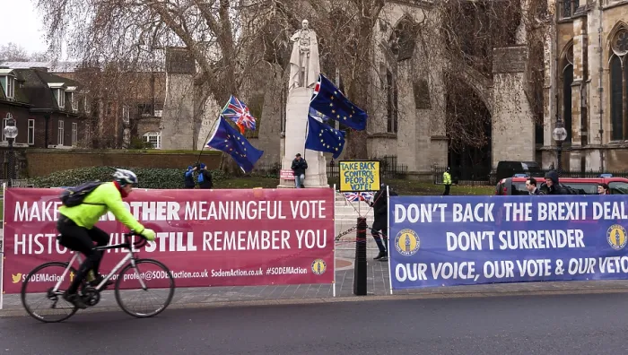 Framed Print : Cyclist rides by an anti-Brexit protest with colorful banners and flags in the City of Westminster