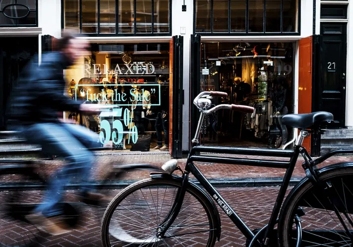 Framed Print : Cyclist rides through shopping street Framed Print : Cyclist rides through shopping street